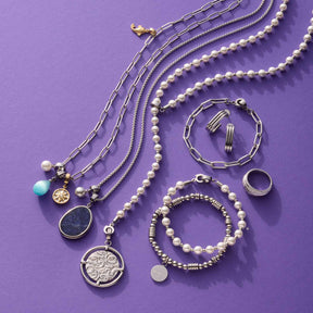 Schmuckkollektion mit Ketten, Armbändern und Ring ELISABETH 17 auf lila Hintergrund