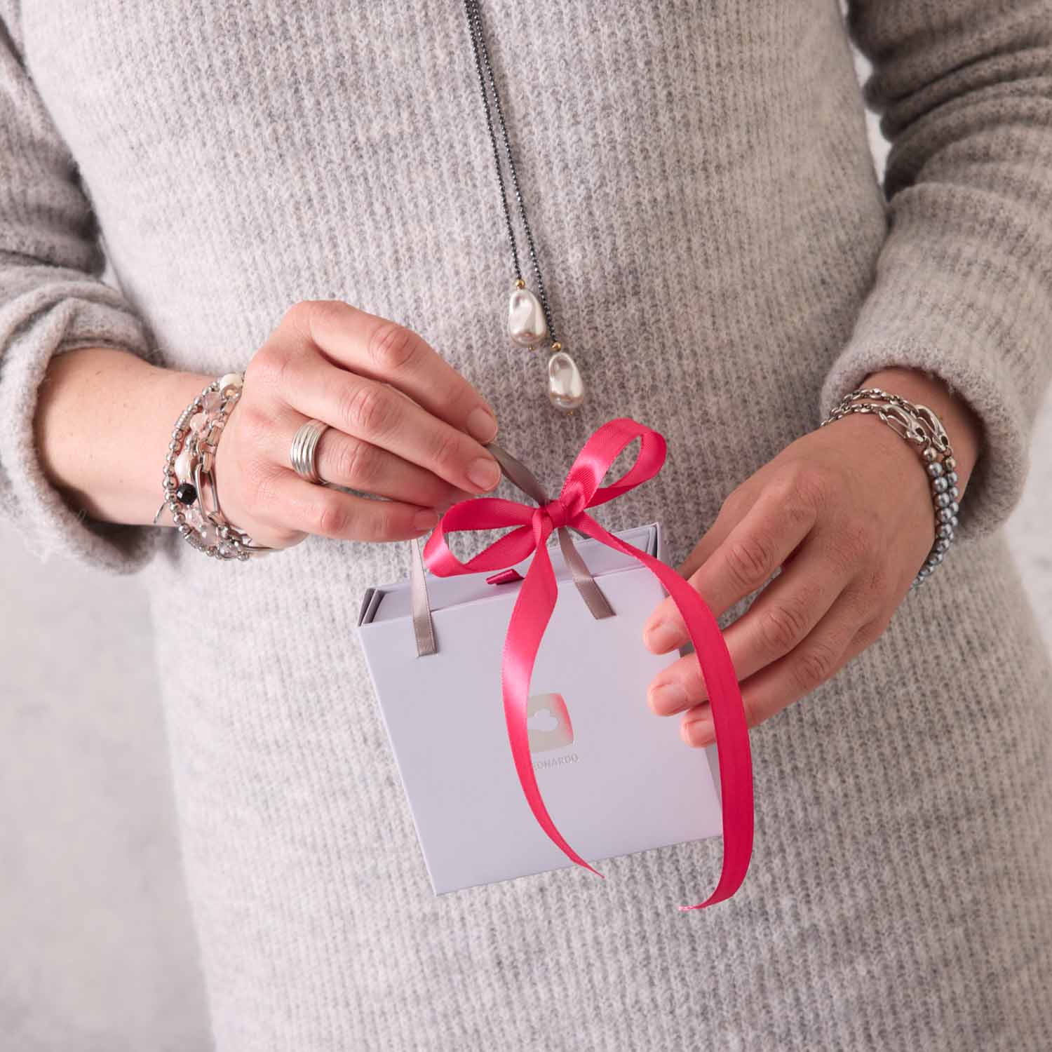 Frau mit Armband DOMINIQUE in Geschenkverpackung mit rosa Schleife