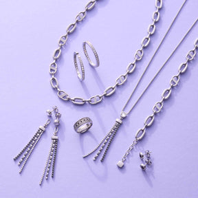Silberner Schmuck der Serie JASMIN auf violettem Hintergrund: Creolen, Ketten, Ohrringe und Ring