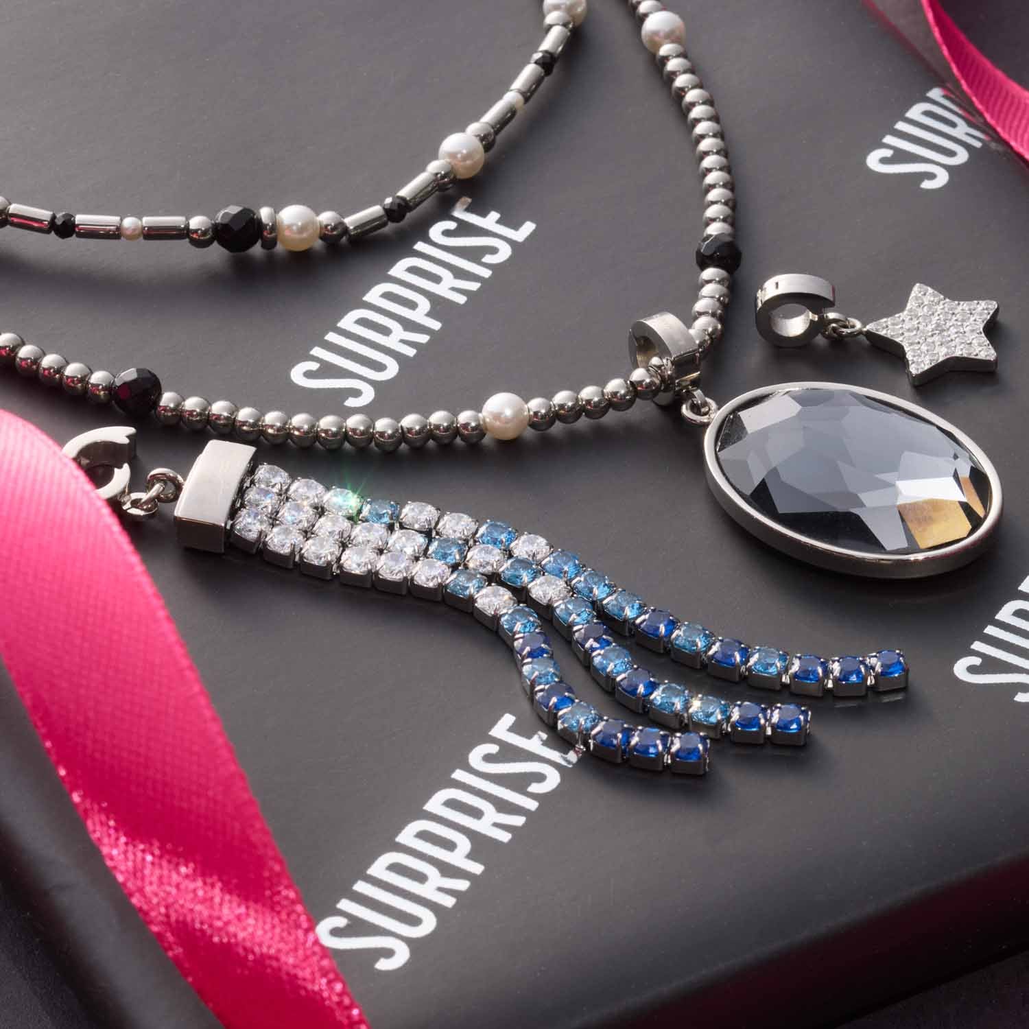 Halskette SABINE mit Glasperlen, Anhängern und rosa Geschenkband auf grauem Untergrund