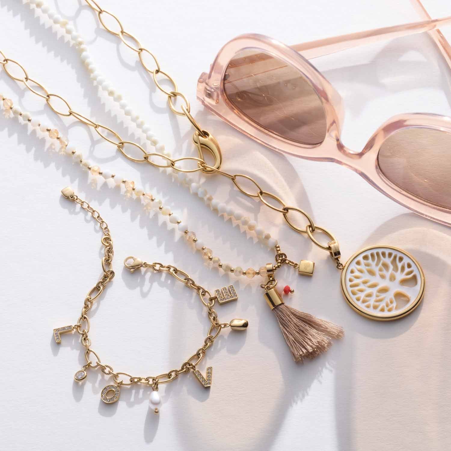 Halskette TORY 80 cm gold mit Schmuckzubehör und Sonnenbrille auf weißem Hintergrund