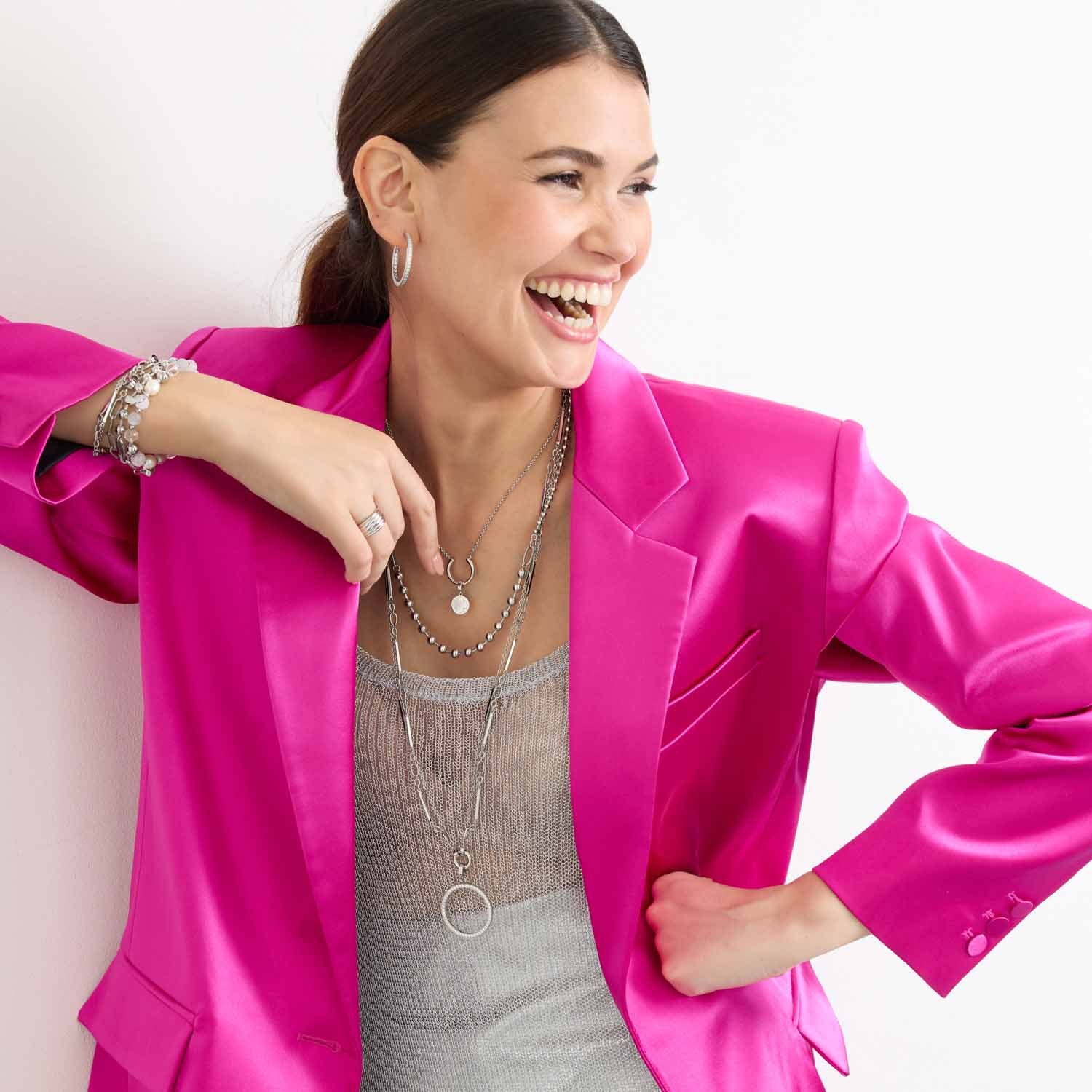 Frau traegt silberne Halskette DOTTY 60 cm Clip & Mix mit Armband, pink Blazer, weisser Hintergrund