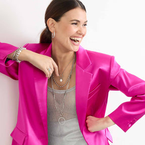 Frau traegt silberne Halskette DOTTY 60 cm Clip & Mix mit Armband, pink Blazer, weisser Hintergrund