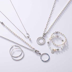 Halskette DOTTY mit Perlen, Ringen und Anhängern auf weißem Hintergrund