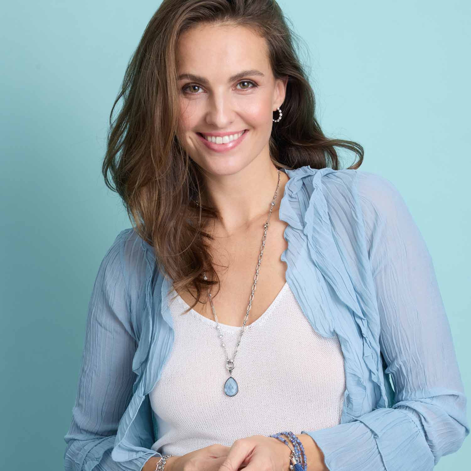 Frau traegt Halskette VICKY mit Glaenzer, hellblauer Cardigan und weissem Top