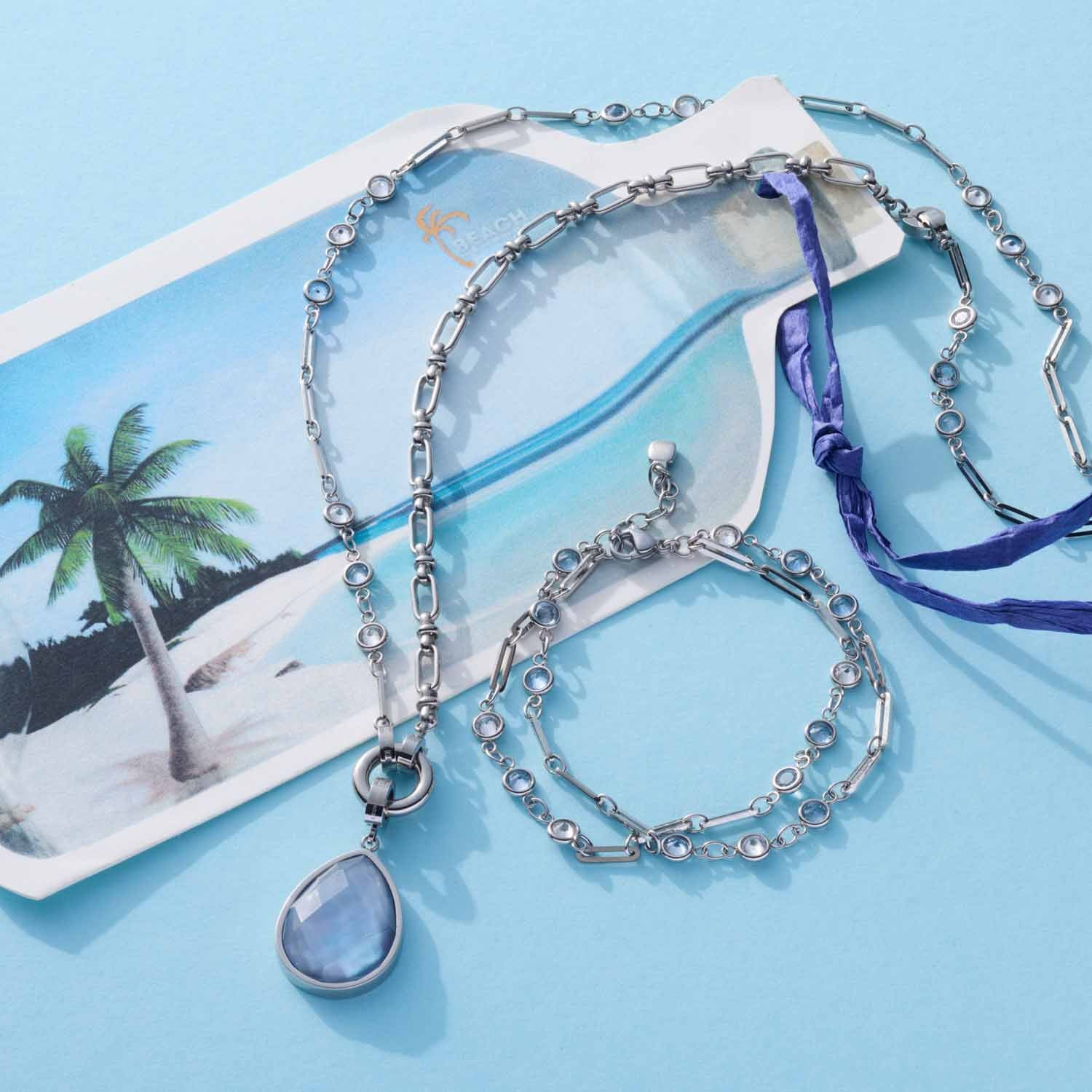 Armband VICKY mit Glasperlenkette und Anhänger auf blauem Hintergrund mit Strandmotiv