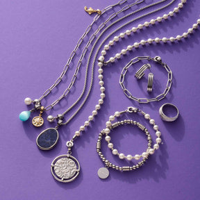 Silberne Schmuckkollektion auf violettem Hintergrund: Ketten, Armbänder, Anhänger TERRY Clip & Mix, Ringe und Ohrringe