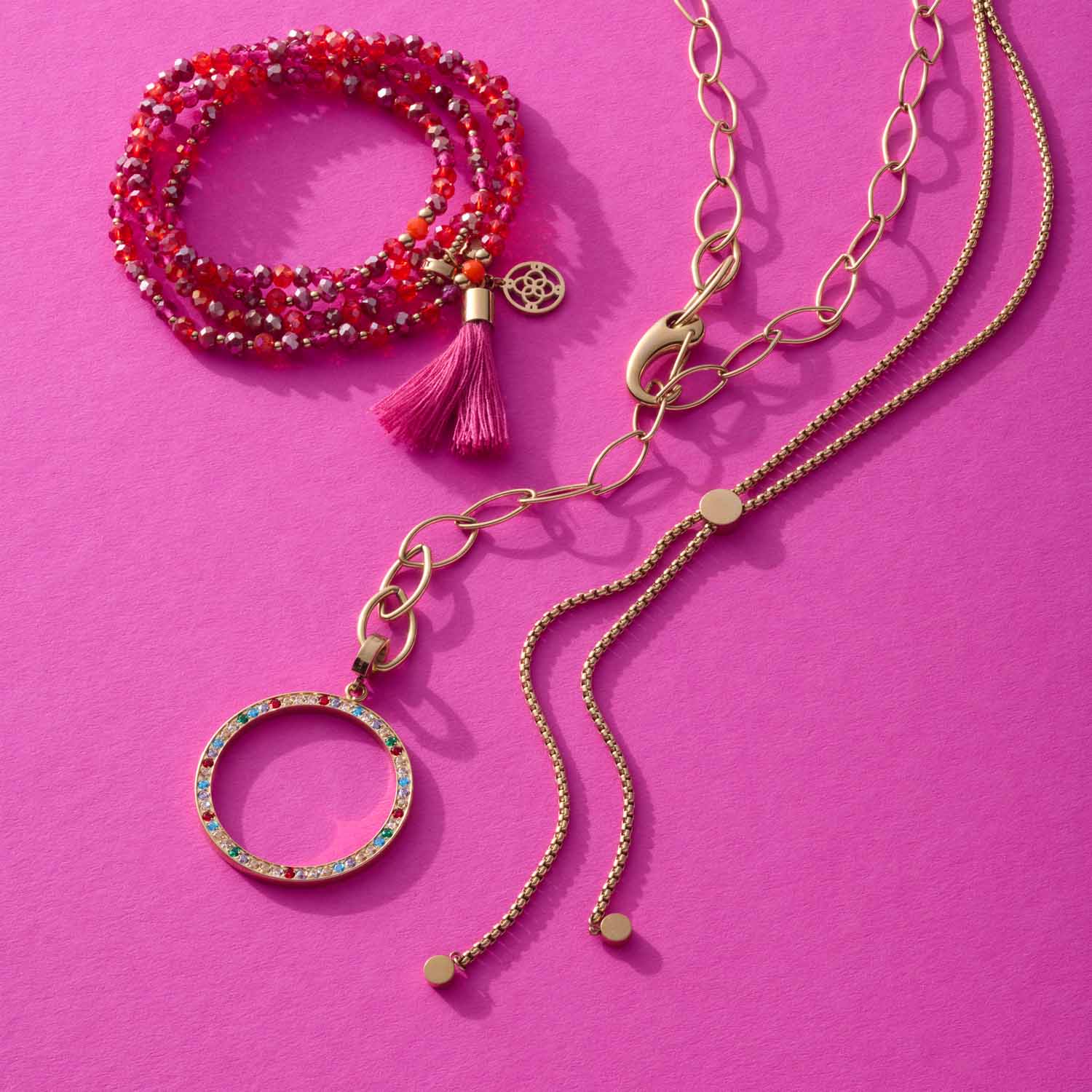 Anhänger CLARENCE gold Clip & Mix mit Ketten und Perlenarmband auf pink Hintergrund