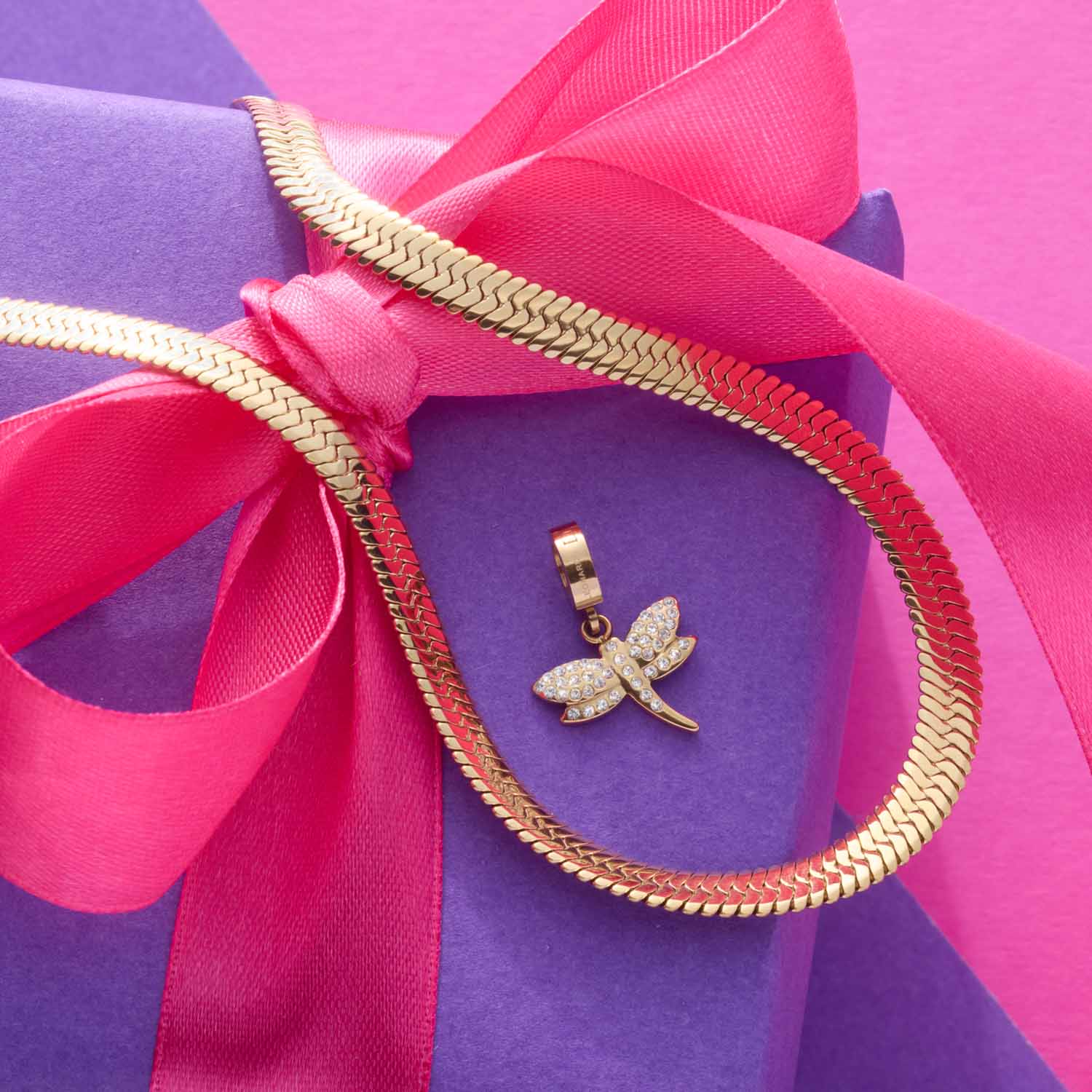 Anhänger ELISABETH Clip & Mix gold auf violettem Untergrund mit pink-roter Schleife
