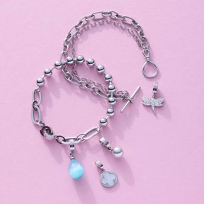 Anhänger ELISABETH Clip & Mix mit Ketten und Charms auf rosa Hintergrund