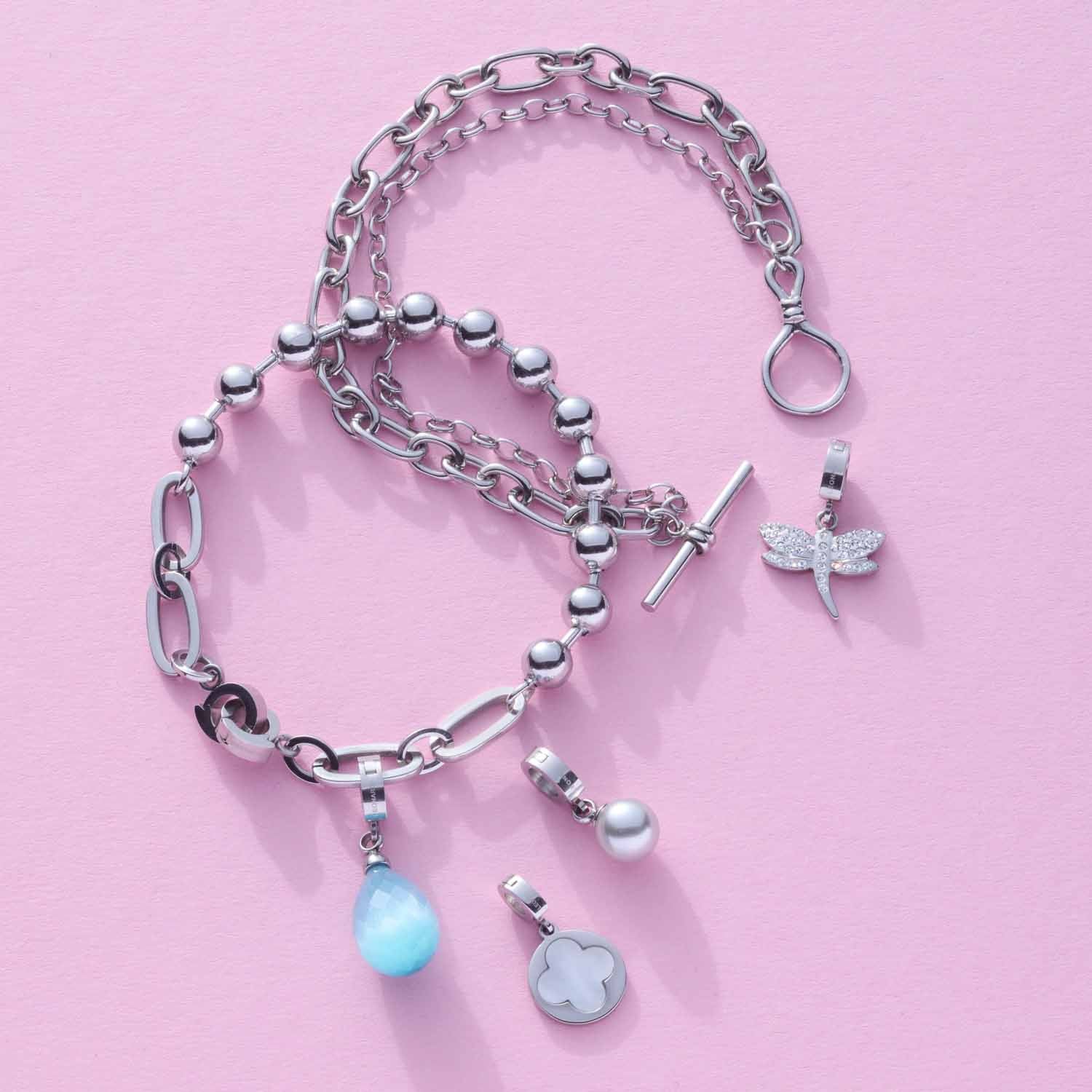 Anhänger LIZZY Clip & Mix mit Ketten und Charms auf rosa Hintergrund