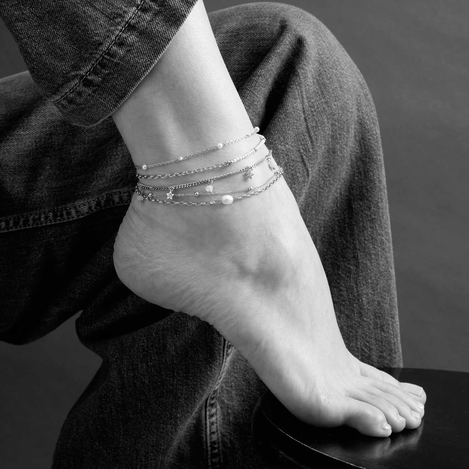 Fußkette NAVINA CIAO silber an Frauenfuß getragen, Schwarzweißaufnahme
