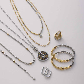Schmuckkollektion mit Armbändern, Ketten und Ringen in Gold und Silber