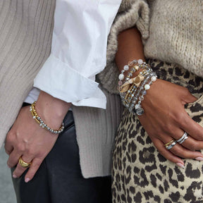 Zwei Frauen tragen Armbänder und Ringe, darunter das Armband PHILINE gold in gold und silber