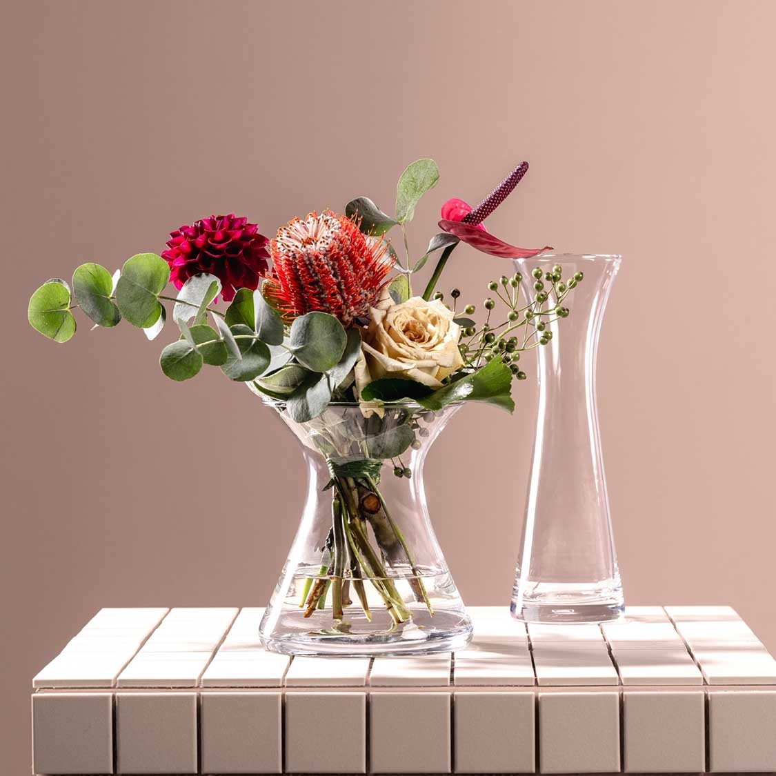 Vase GIA 16 cm mit Schnittblumen auf weißem Tisch, beige Hintergrund