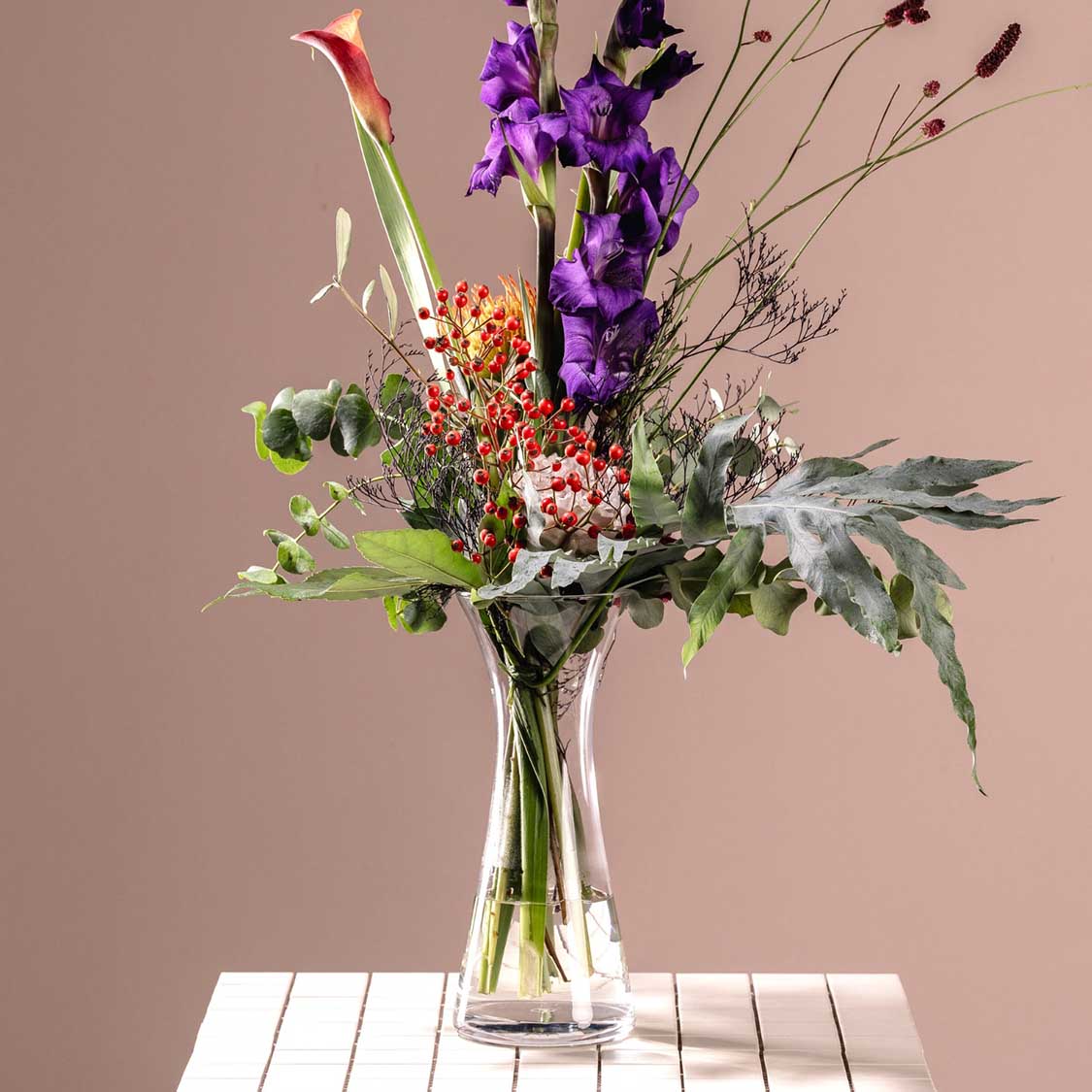 Vase GIA mit buntem Blumenstrauß auf weißem Tisch