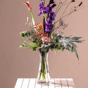 Vase GIA mit buntem Blumenstrauß auf weißem Tisch