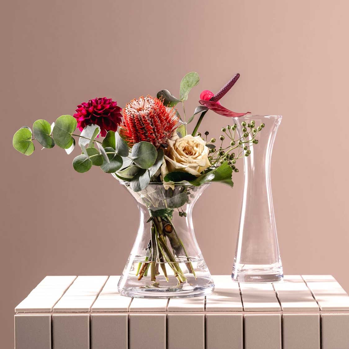 Solifleurvase GIA mit buntem Blumenstrauß auf weißem Holztisch