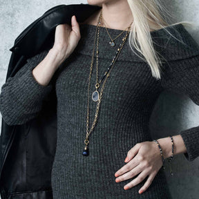 Frau traegt Armband ALINE gold an der Hand, mit schwarzer Jacke und Halskette