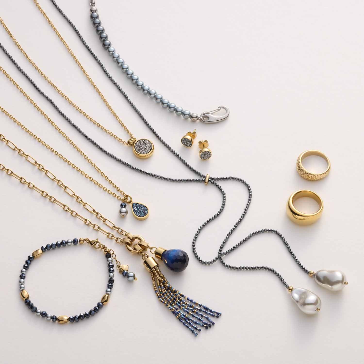 Schmuckkollektion mit Armbändern, Halsketten, Ringen und Ohrringen in Gold, Silber und Dunkelblau