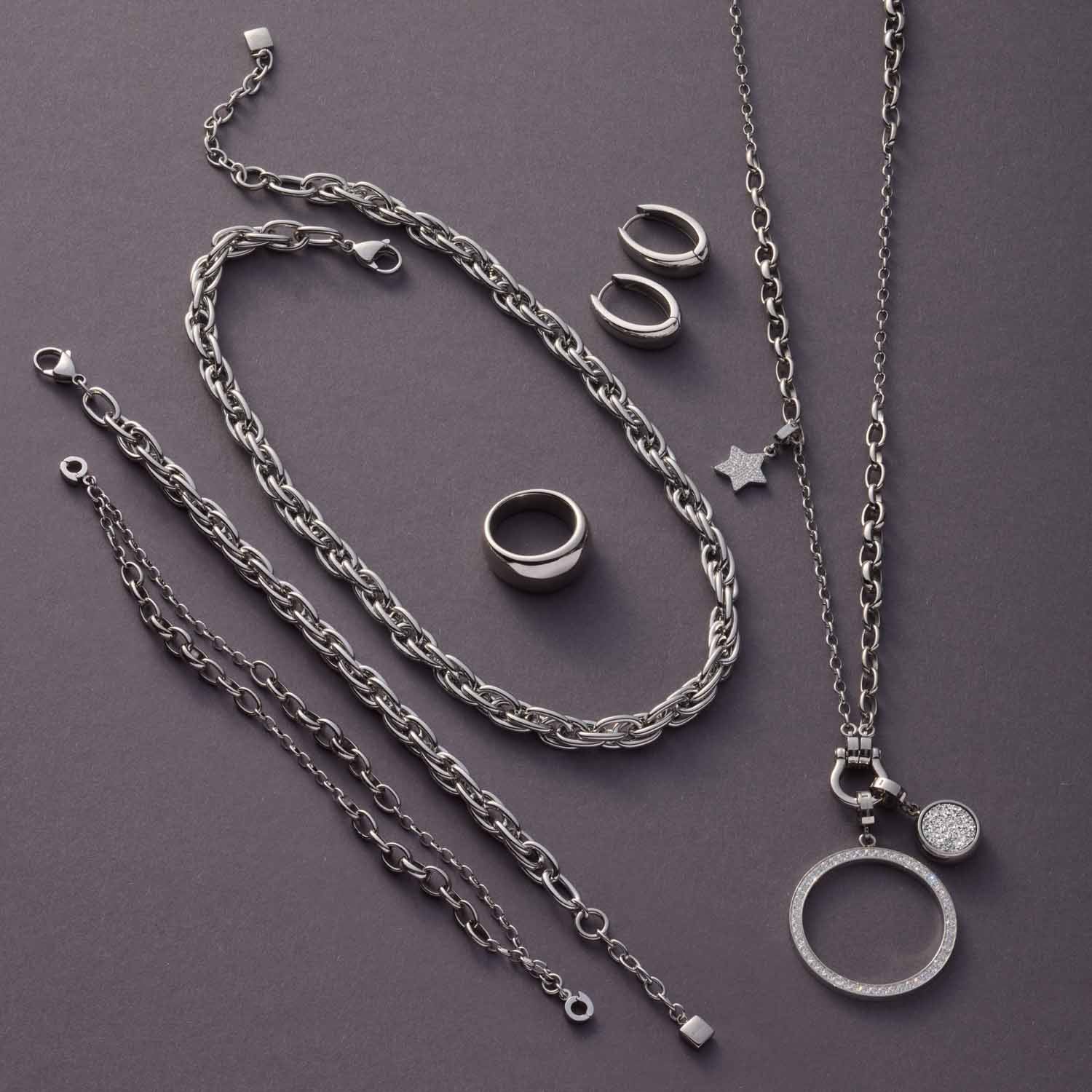 Armband Sina silber mit Ketten, Ringen und Anhängern auf grauem Hintergrund