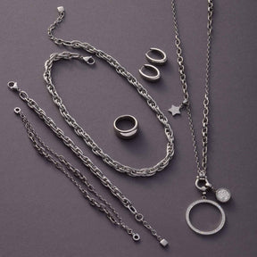 Armband Sina silber mit Ketten, Ringen und Anhängern auf grauem Hintergrund