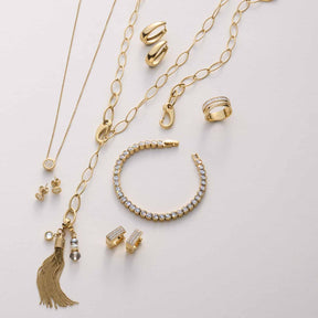Goldschmuck-Kollektion mit Ohrsteckern, Ketten, Ringen und Armband auf weißem Hintergrund