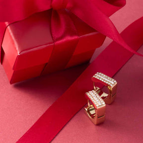 Creole SARAH gold mit Zirkonia auf rotem Geschenkband und Geschenkbox