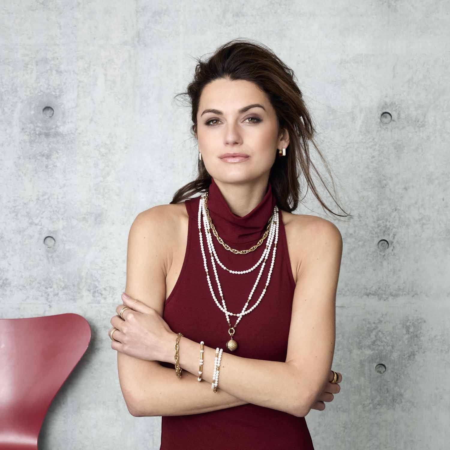 Frau trägt Creole SARAH gold mit Halsketten und Armbändern