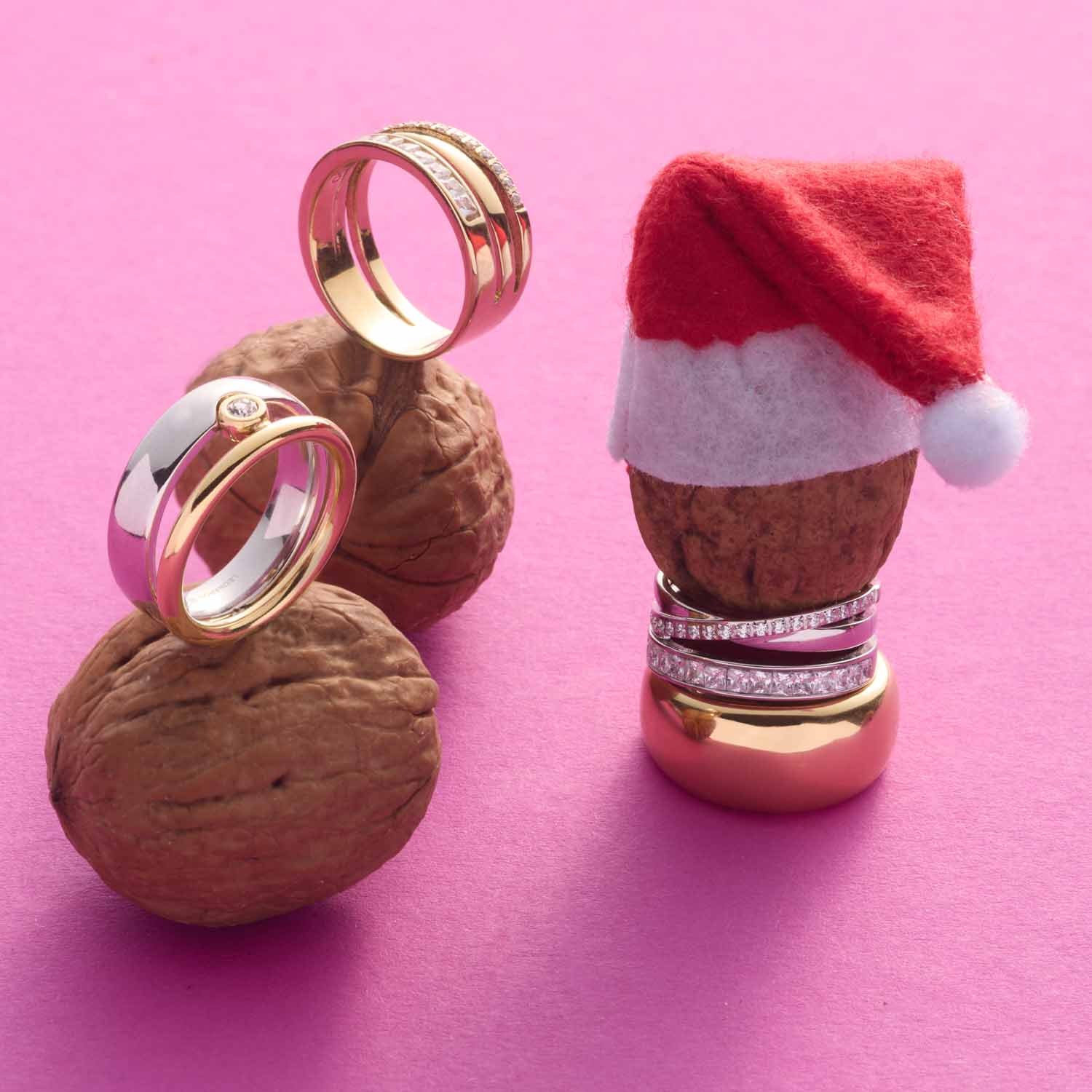 Ring SARAH 20 auf Walnüssen neben weihnachtlich dekorierter Figur auf rosa Untergrund