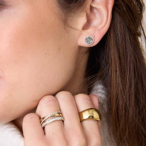 Frau traegt Ring SARAH 20 gold an der Hand, dazu Ohrringe und weitere Ringe