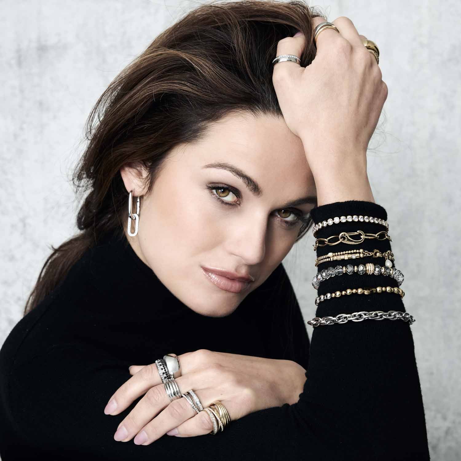 Frau traegt Ring SARAH 20 gold an Hand mit Armbaendern