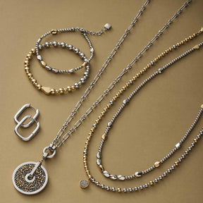Silberner Schmuck auf beigem Untergrund: Creole BERNICE, Ketten, Armbänder und Ohrringe aus Edelstahl