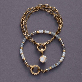 Armband BERNIE Clip & Mix gold mit Glasperlen in Weiß und Grau auf grauem Hintergrund