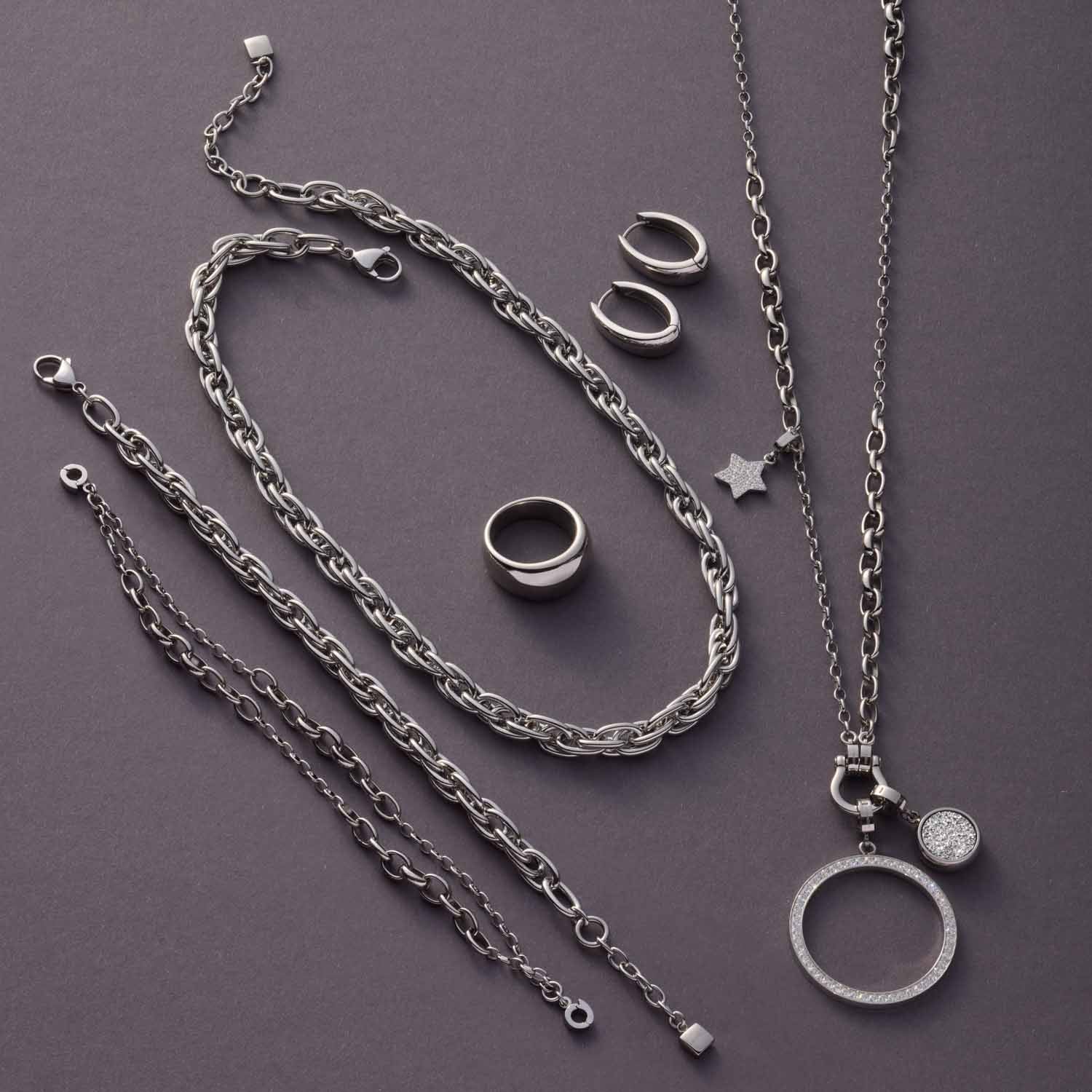 Halskette SUZANNE mit Ketten, Ringen und Anhängern in Silber auf grauem Untergrund