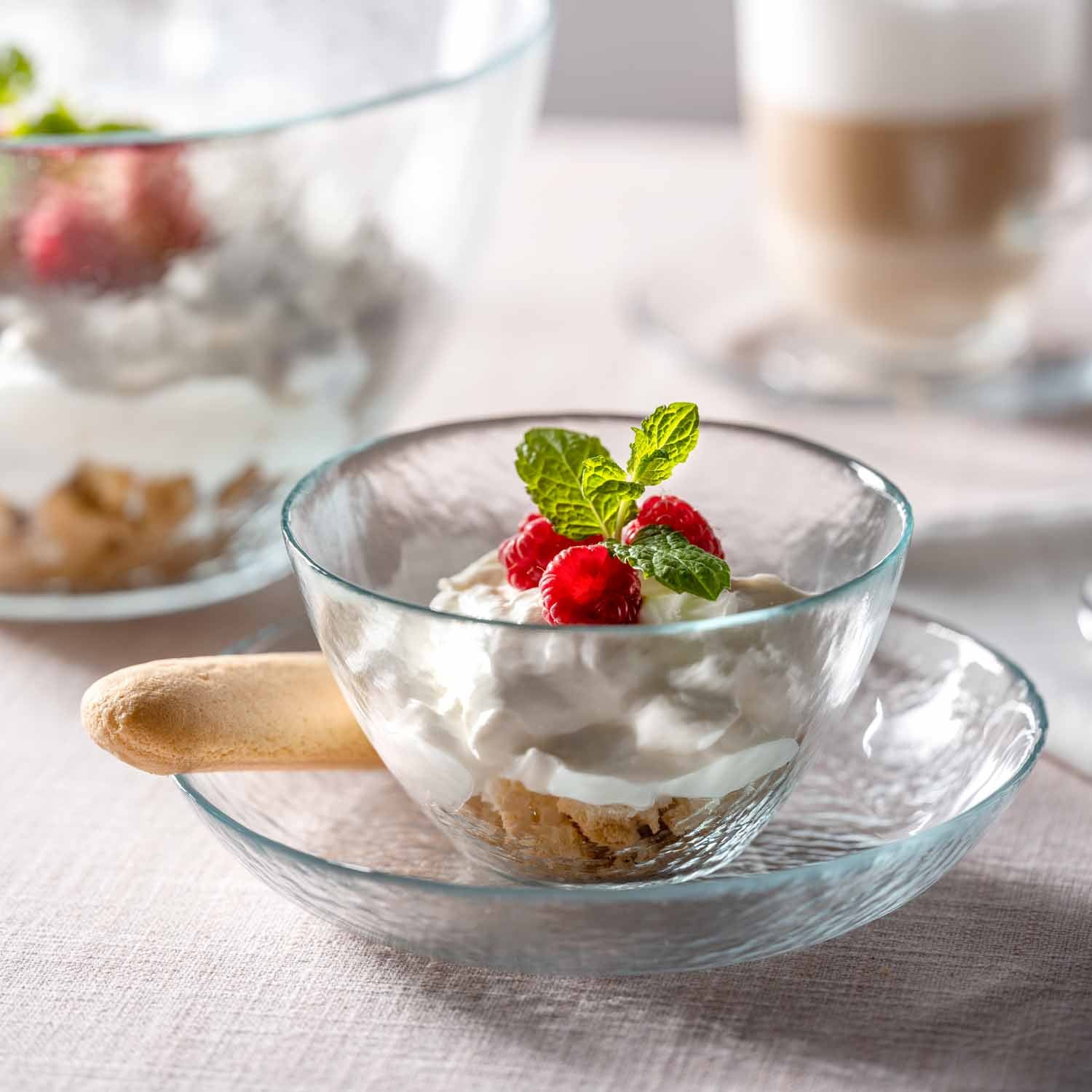 Schale ATTIVO mit Joghurt, Müsli und Himbeeren auf gedecktem Tisch