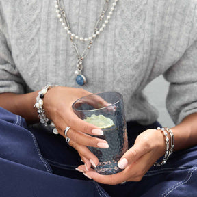 Frau mit Schmuck hält Glas-Anhänger SNOWBALL BLUE in der Hand