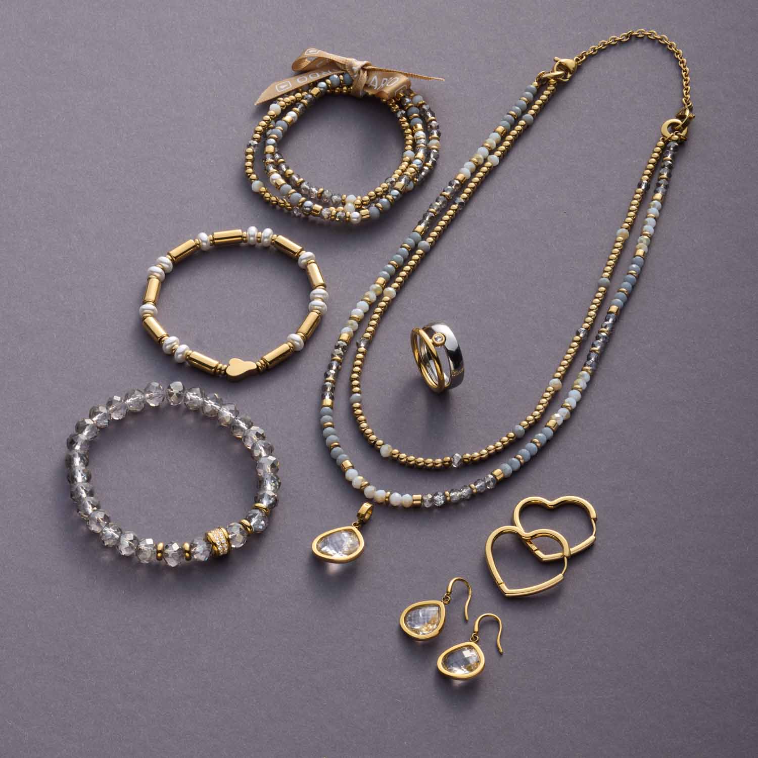 Schmuckkollektion aus Glas mit Armbändern, Kette und Ohrhängern in Gold und Weiß