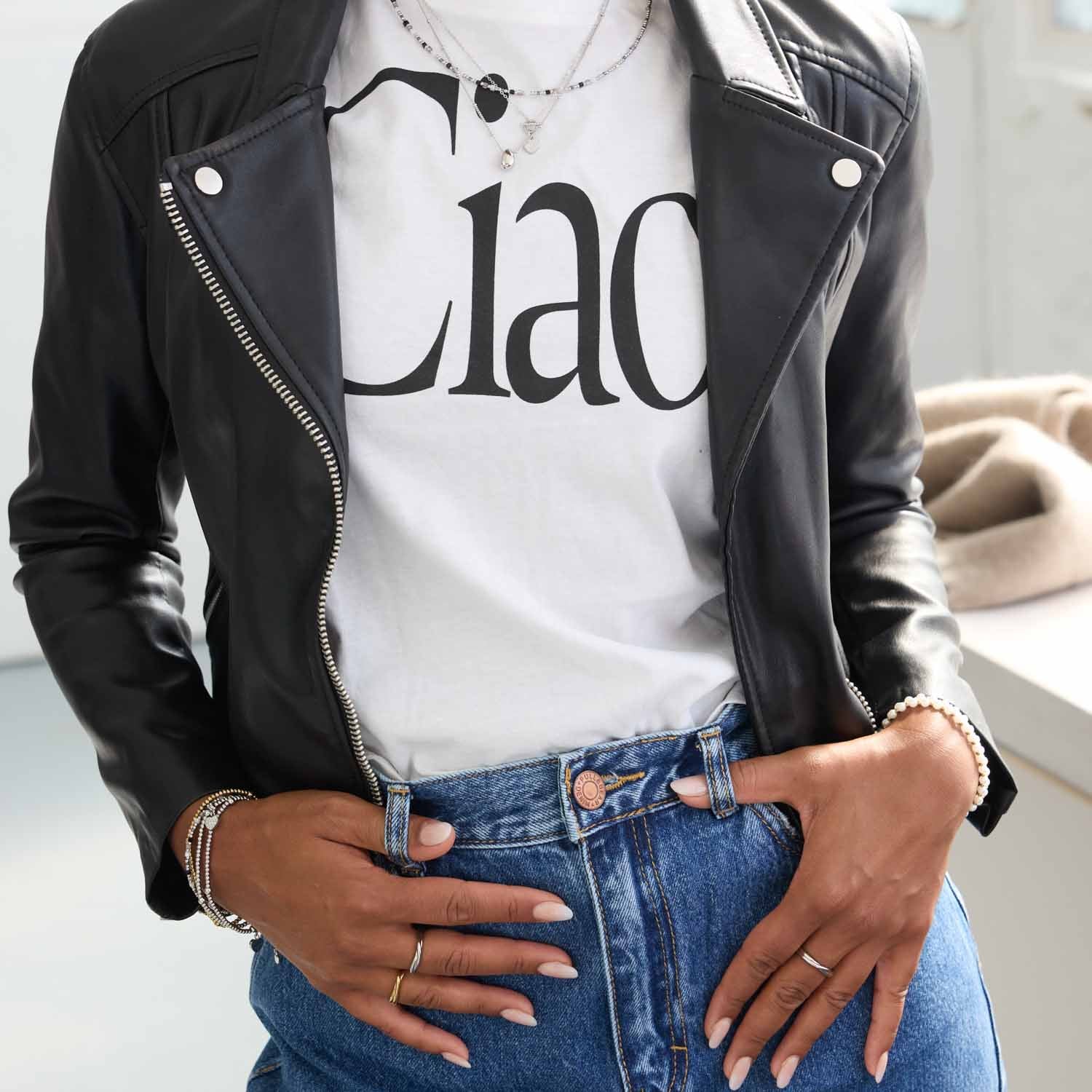 Frau trägt Armband LIZO CIAO an Handgelenk, schwarze Lederjacke, weißes T-Shirt, blaue Jeans