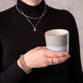 Frau traegt silbernes Armband NOEMI CIAO mit Keramiktasse und Halsketten