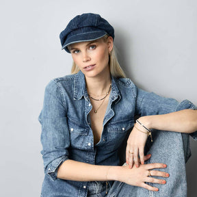 Frau traegt Halskette CLOTHILDE gold mit Denim-Hemd und Kappe