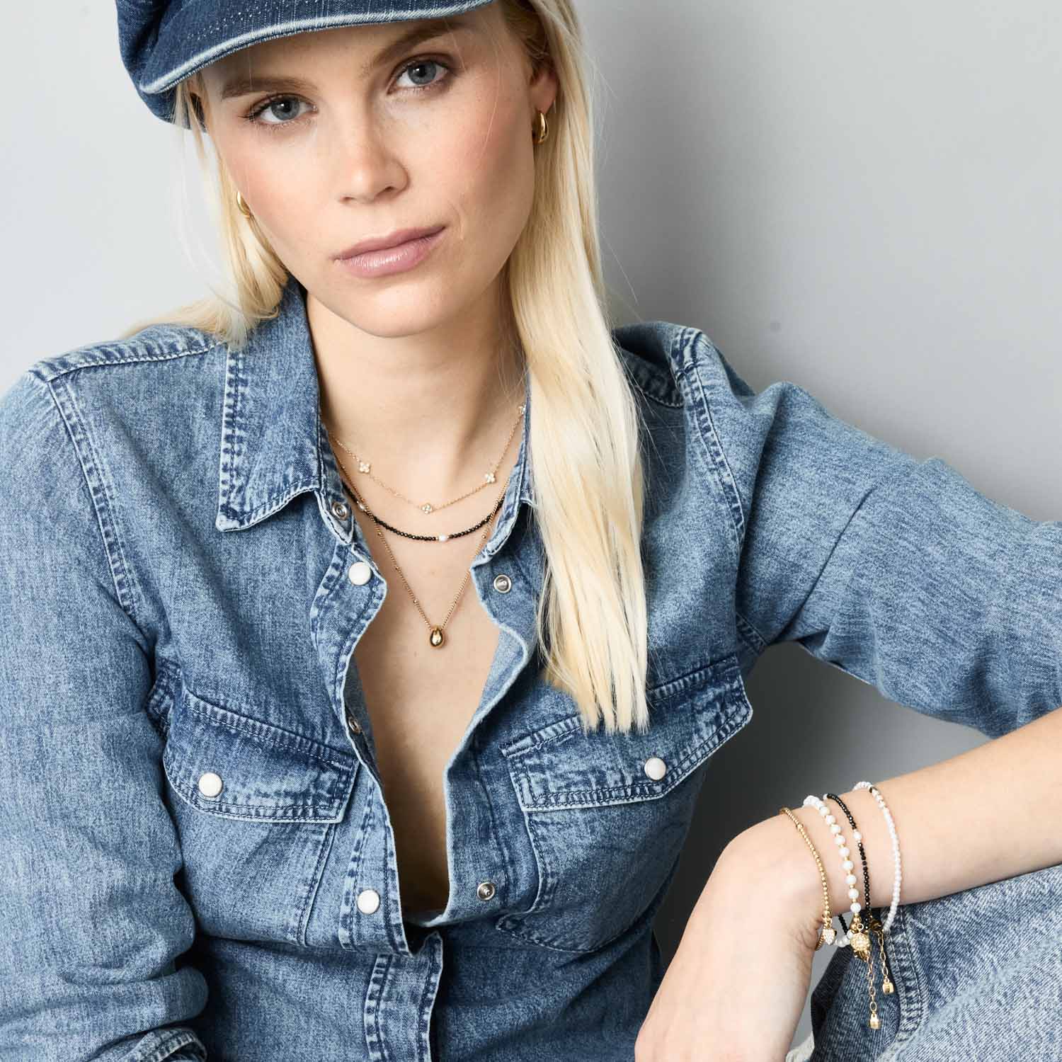 Frau traegt Halskette LISETTE gold mit Denim-Hemd und Kappe