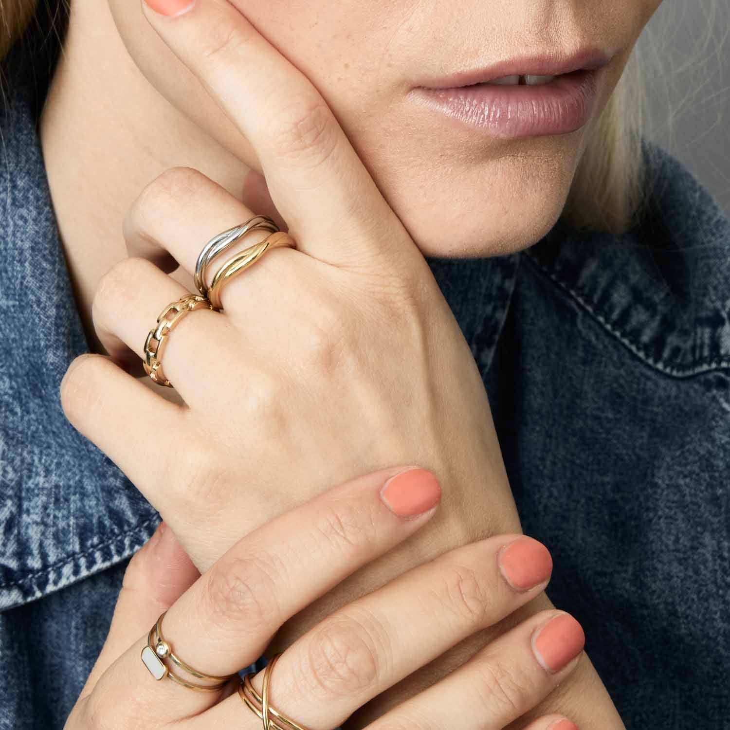 Frau traegt Ring TWISTER 20 gold an Hand, Detailaufnahme