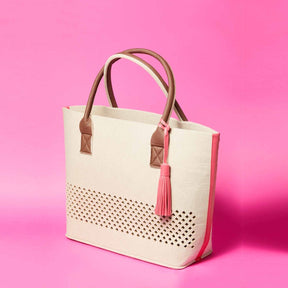 LEONARDO Beach Bag pink auf rosa Hintergrund mit braunen Henkeln und rosa Troddel