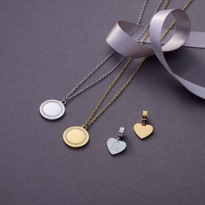 Halskette FERRARA mit Anhängern in Silber und Gold auf grauem Untergrund mit Schleife