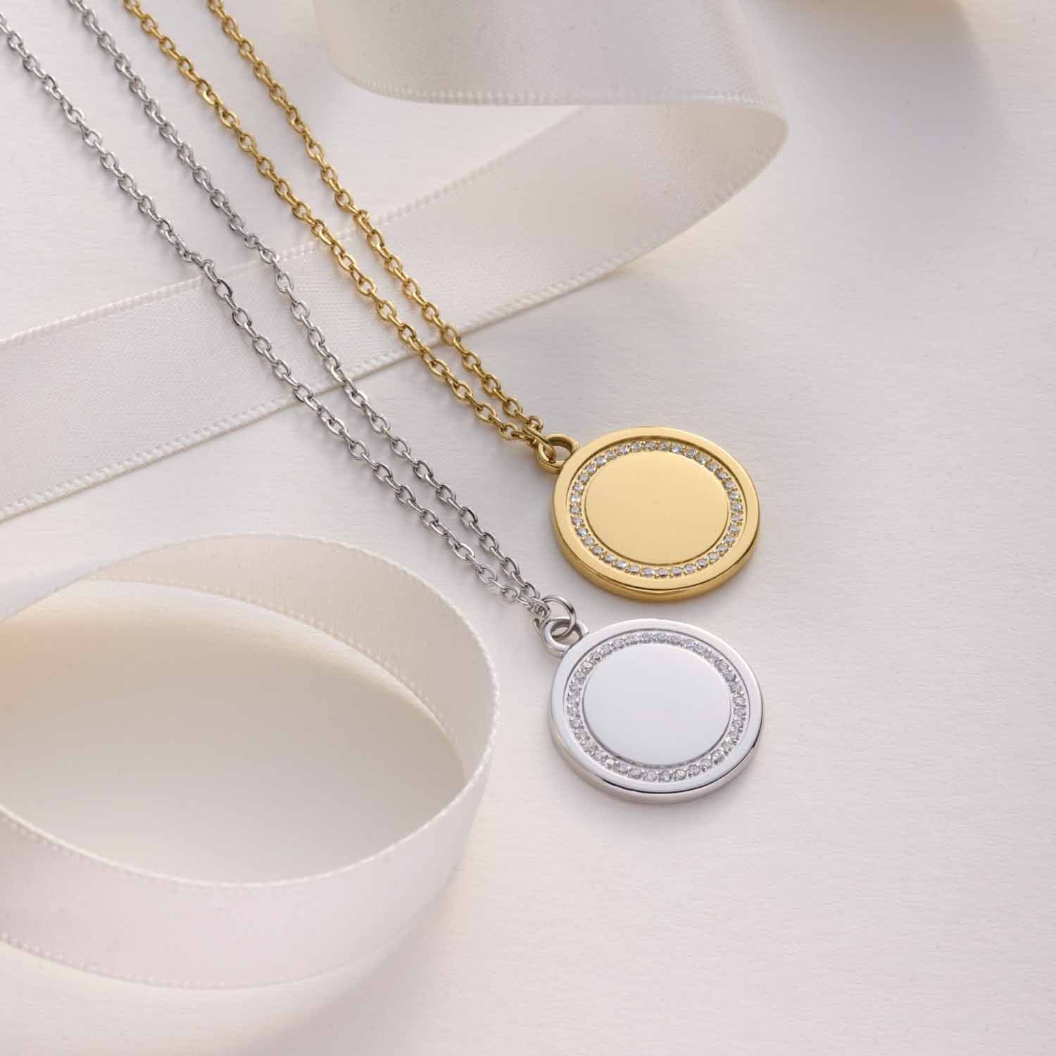 Zwei Halsketten FERRARA mit runden Anhängern in Gold und Silber auf weißem Untergrund