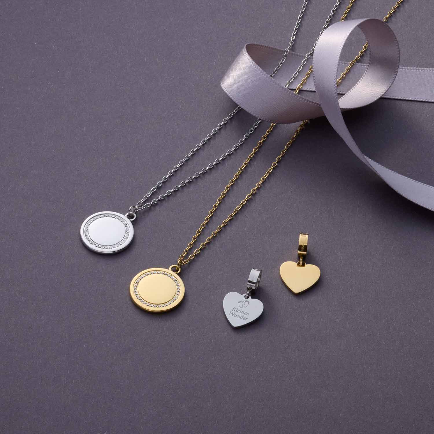 Halskette FERRARA mit runden Anhängern in Gold und Silber, teilweise mit Gravur, auf grauem Untergrund
