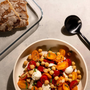 Platte CIAO mit Kichererbsen-Gemüsesalat auf Tisch mit Besteck und Brot