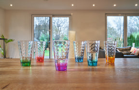 Sechs farbige Trinkgläser OPTIC 300 ml auf Holztisch in Wohnraum