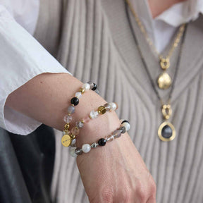Frau traegt mehrere Armbänder HOPE gold/rose am Handgelenk mit Perlen und Metallperlen, dazu passende Halskette